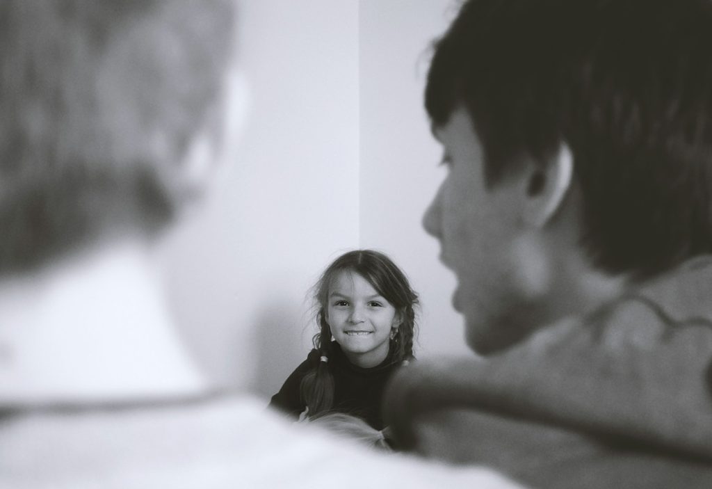 Niña escuchando a sus padres en un momento familiar