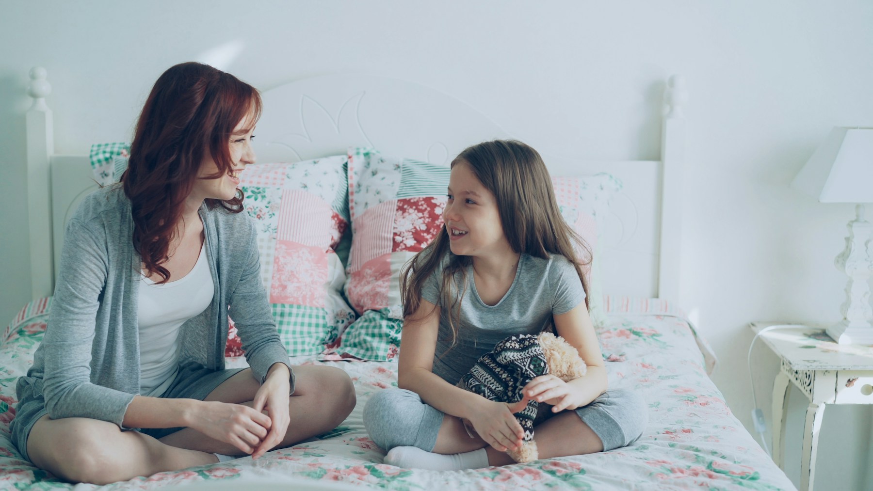 Madre e hija conversando en un dormitorio